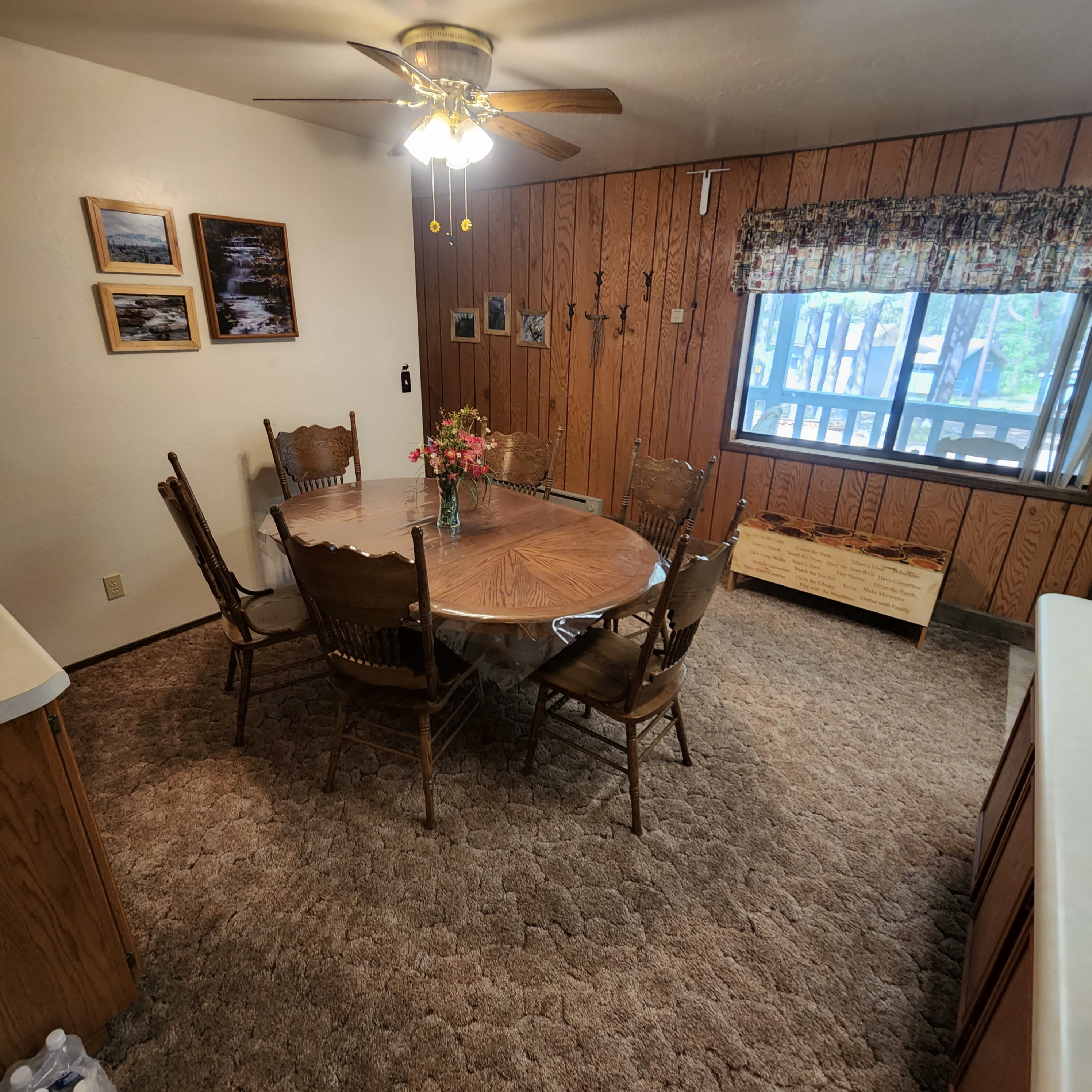 Dining Room - The dining and game area has a table that seats 6. There are also two benches available (see one under the window) for additional seating if needed. The window looks out to the trees in the front drive area.