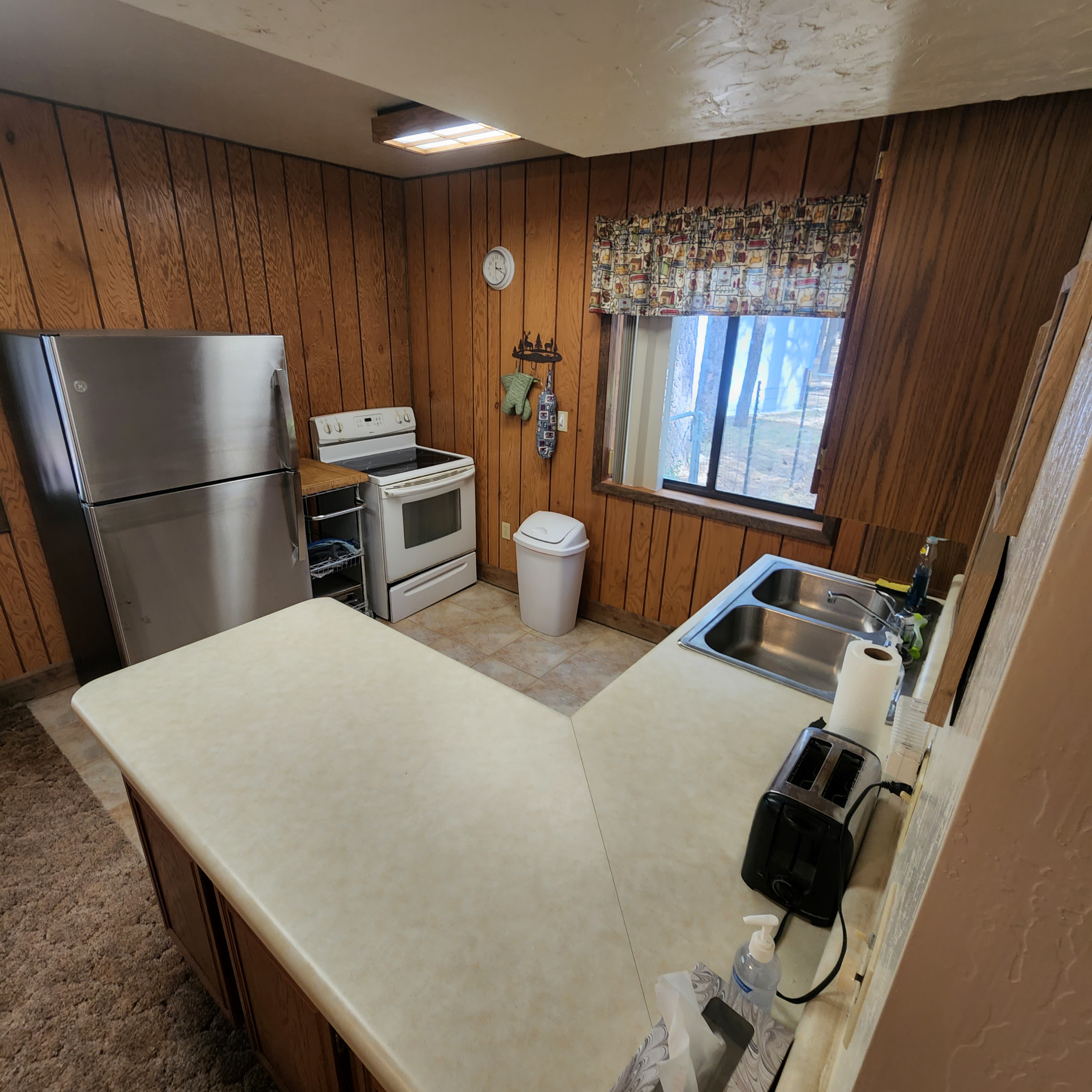 Kitchen - The kitchen cabinets are fully stocked with everything needed to cook and enjoy life at the cabin including an electric stove, oven, serving cart and a full size refrigerator freezer.