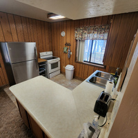 The kitchen cabinets are fully stocked with everything needed to cook and enjoy life at the cabin including an electric stove, oven, serving cart and a full size refrigerator freezer.